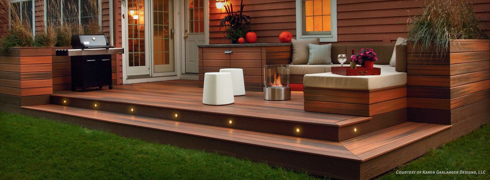 Brown Fiberon deck with steps and outdoor sofas in front of a red-sided house